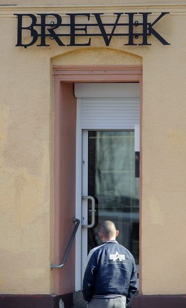 A man walks past a shop named "Brevik" o